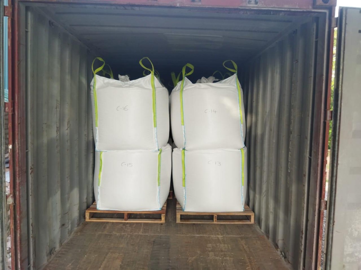 Container interior with stacked jumbo bags, strapped and ready for sealing