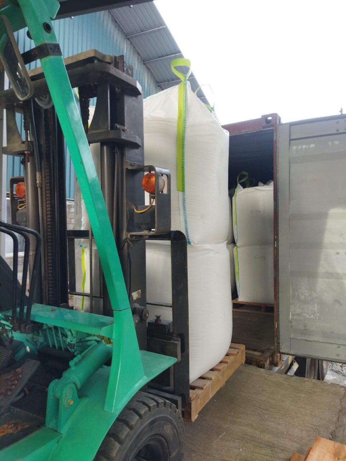 Forklift loading labelled jumbo bags into a shipping container at the Sri Lankan factory
